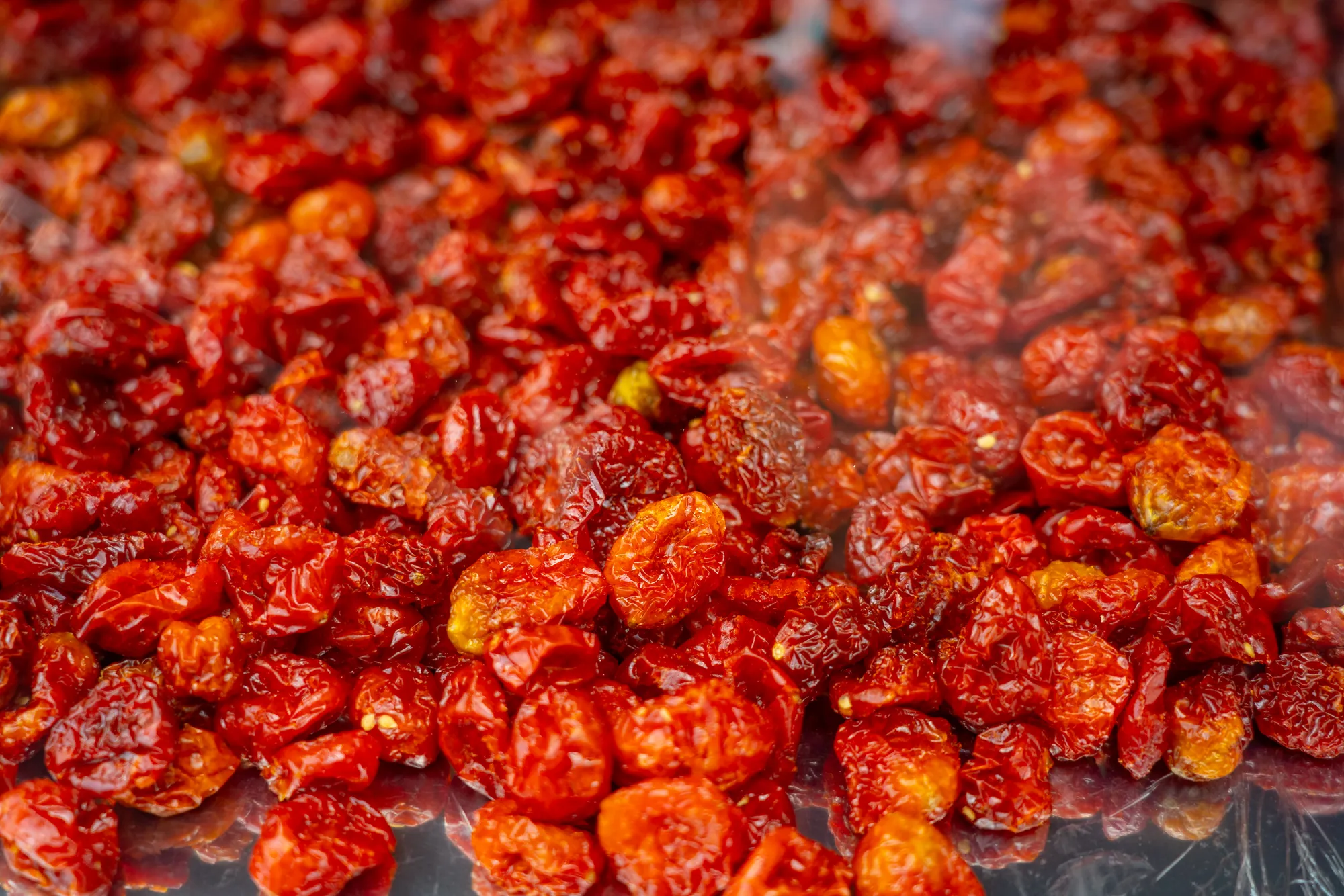 特寫鏡頭展示色澤紅潤的聖女番茄乾，果肉飽滿且帶有濕潤光澤，保留了天然番茄的酸甜風味與軟Q口感