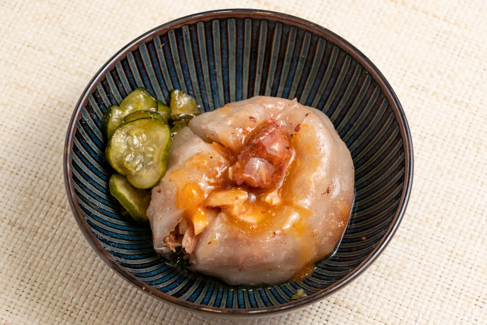 特寫碗中的台灣傳統小吃肉圓 (Ba-wan)，晶瑩剔透的Q彈外皮淋上特製甜辣醬，搭配爽脆的醃黃瓜片，呈現道地風味