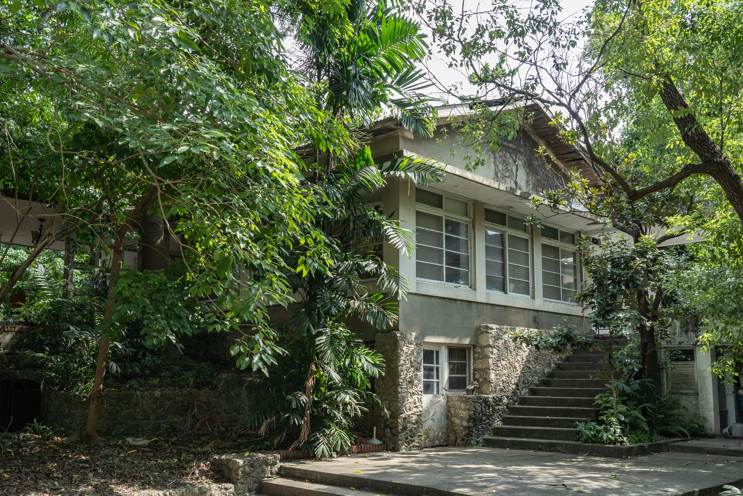 高雄橋仔頭糖廠藝術村內被綠意包圍的歷史建築,保留了日治時期的工業遺址風貌,現轉型為藝文展演空間與藝術家駐村基地