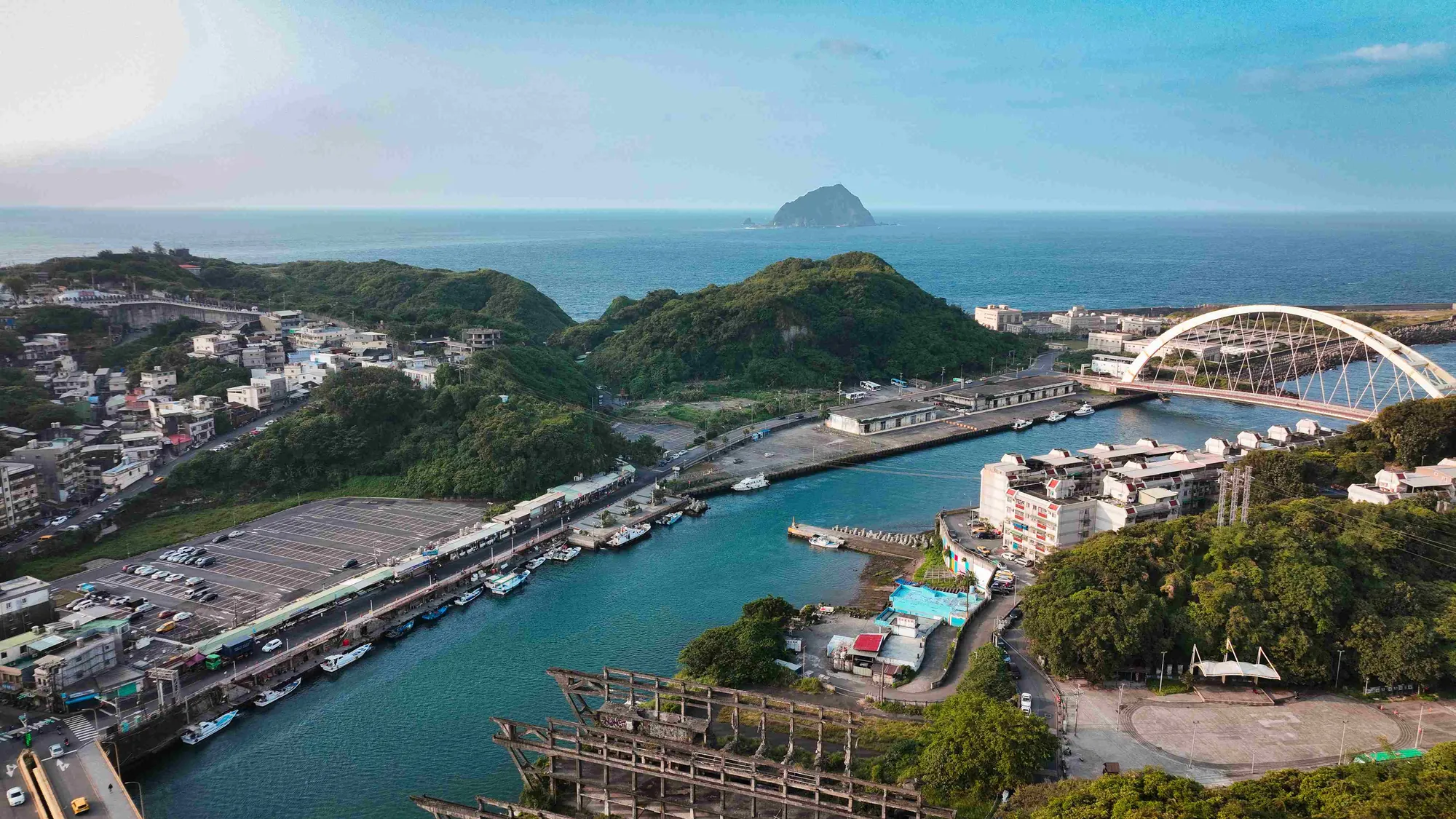 俯瞰宜蘭南方澳漁港全景，白色的跨海大橋橫越港口，遠眺海面上的龜山島，呈現台灣三大漁港之一的壯麗地景