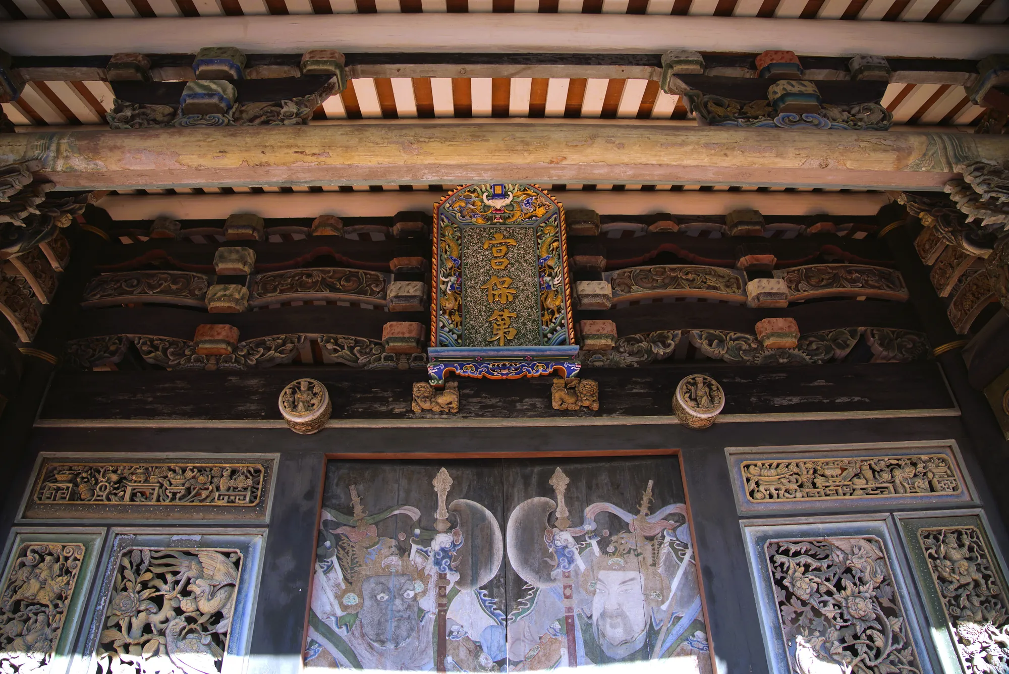 台中霧峰林家宮保第古蹟匾額，細緻傳統木雕斗拱與門神彩繪，展現台灣古厝建築之美。