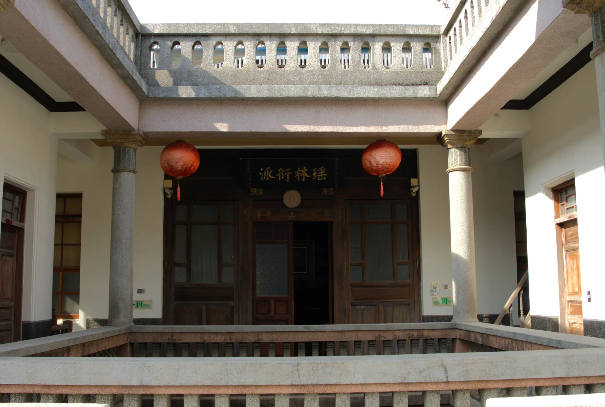 雲林西螺延平老街古厝天井，展示融合中西風格的洗石子欄杆、紅燈籠與木門匾額「瑤林衍派」