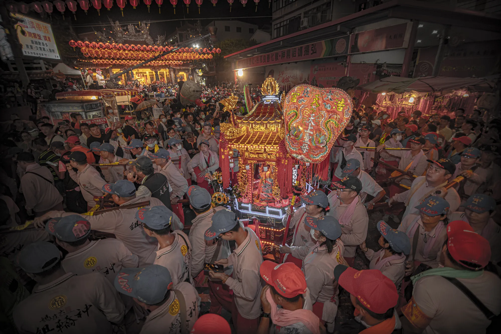 台灣大甲媽祖遶境進香盛況，信眾簇擁著華麗的神轎在夜間行進，展現世界三大宗教盛事之一的熱鬧氛圍與民間信仰力量