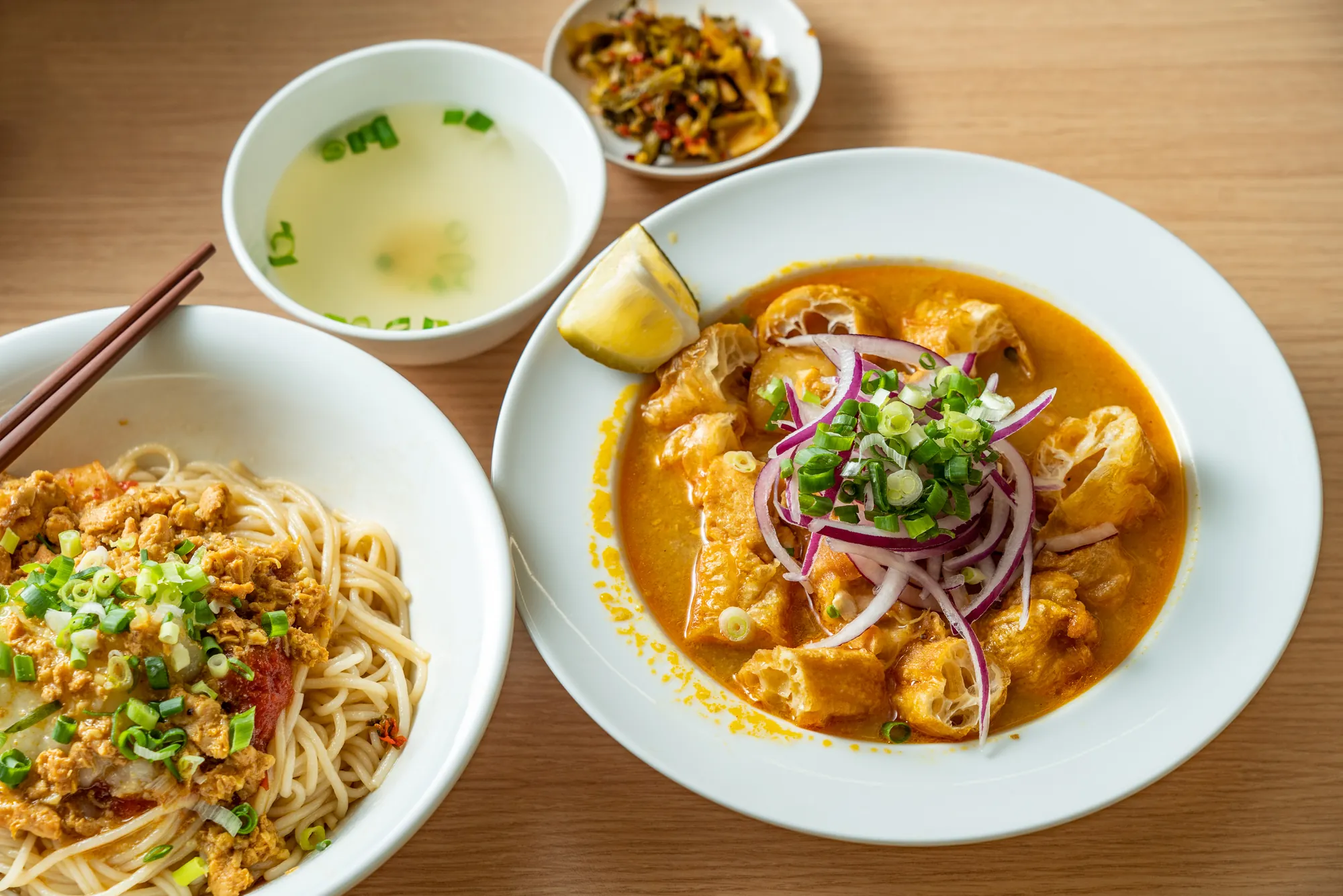 華新街的道地緬甸魚湯麵與乾拌麵套餐，搭配新鮮檸檬角、紫洋蔥及一碗清湯。