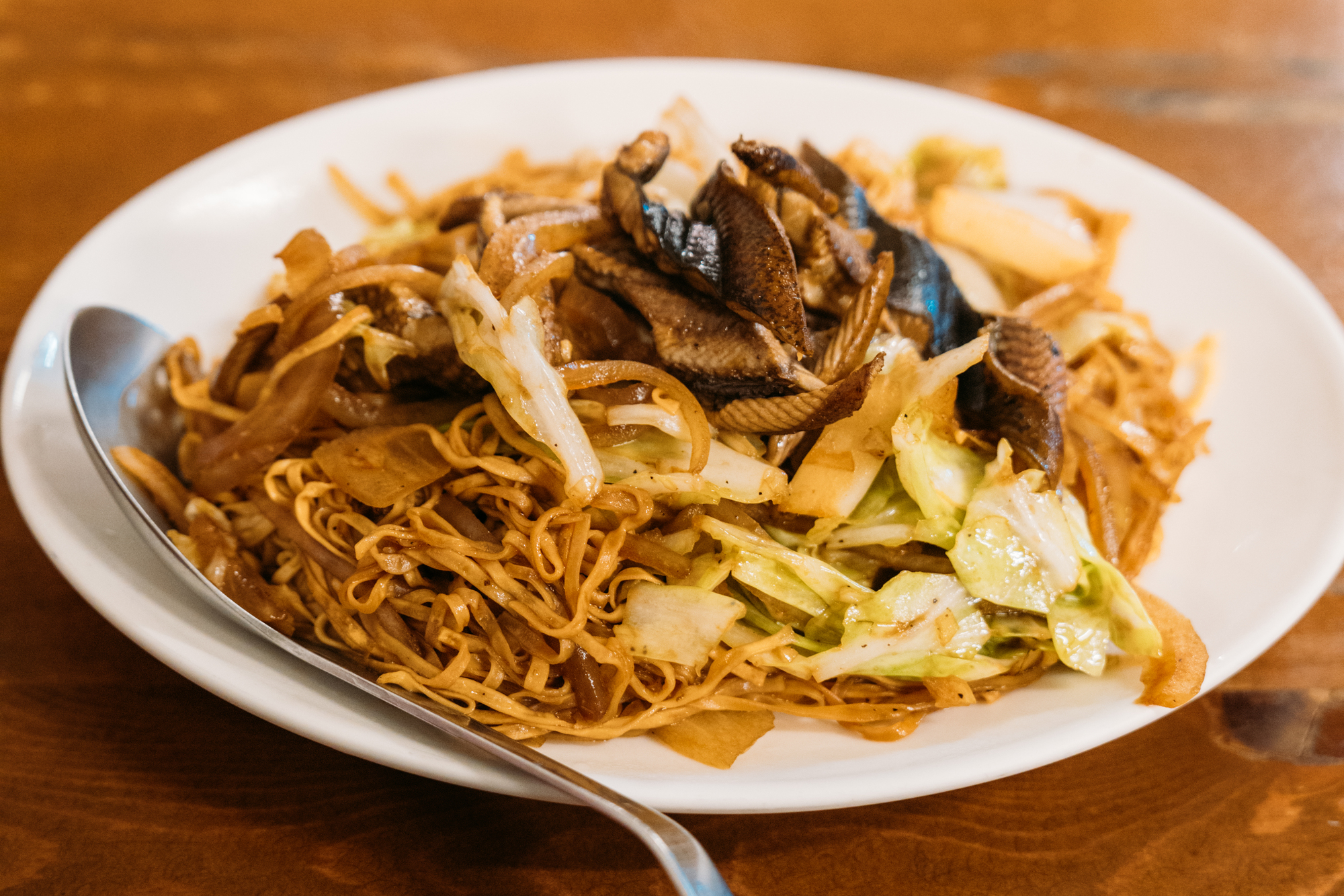 台南意麵盛於白盤中，搭配高麗菜與滷味配料