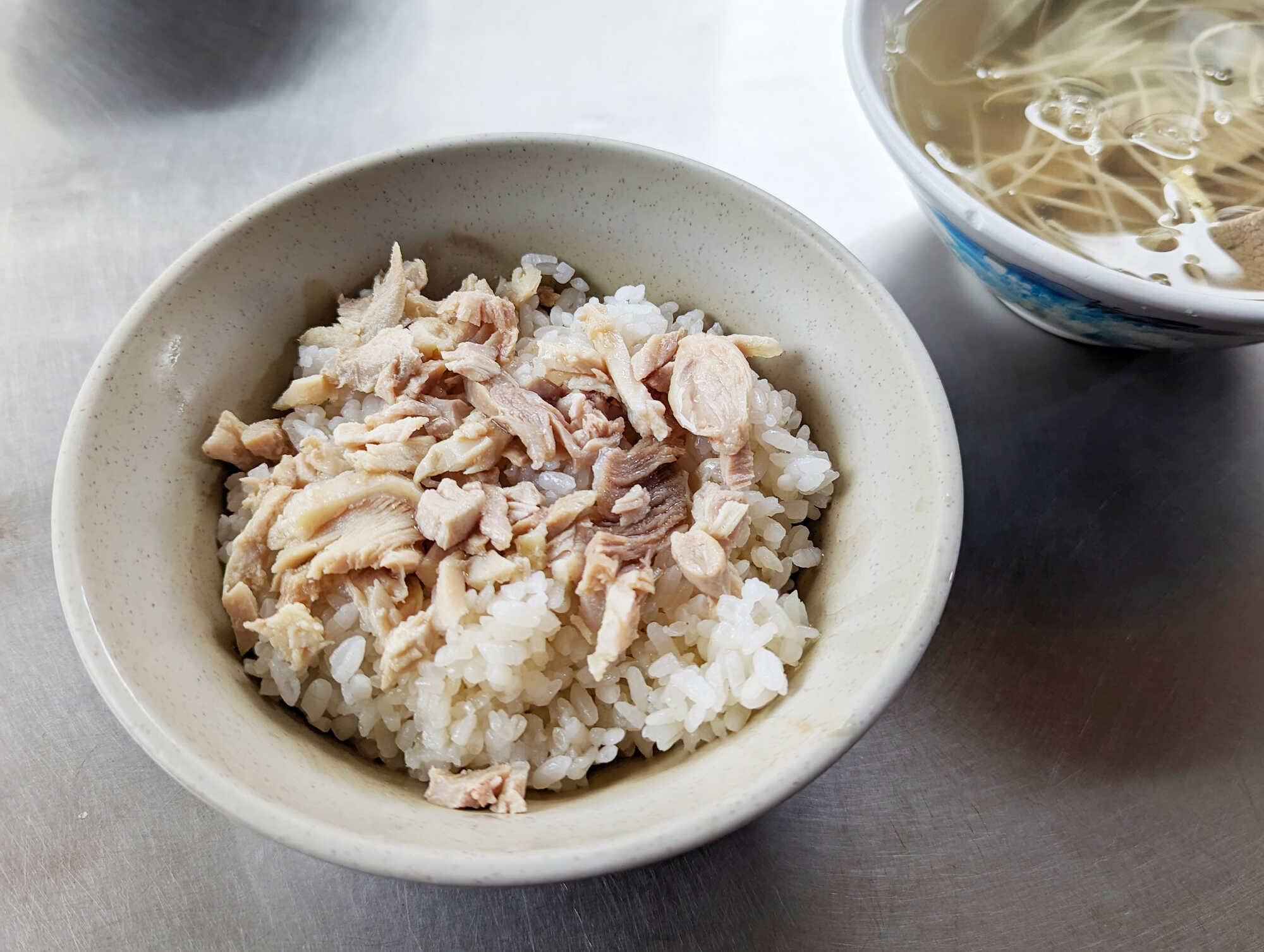 嘉義東市場雞肉飯,白飯鋪上雞肉絲並搭配一碗清湯。