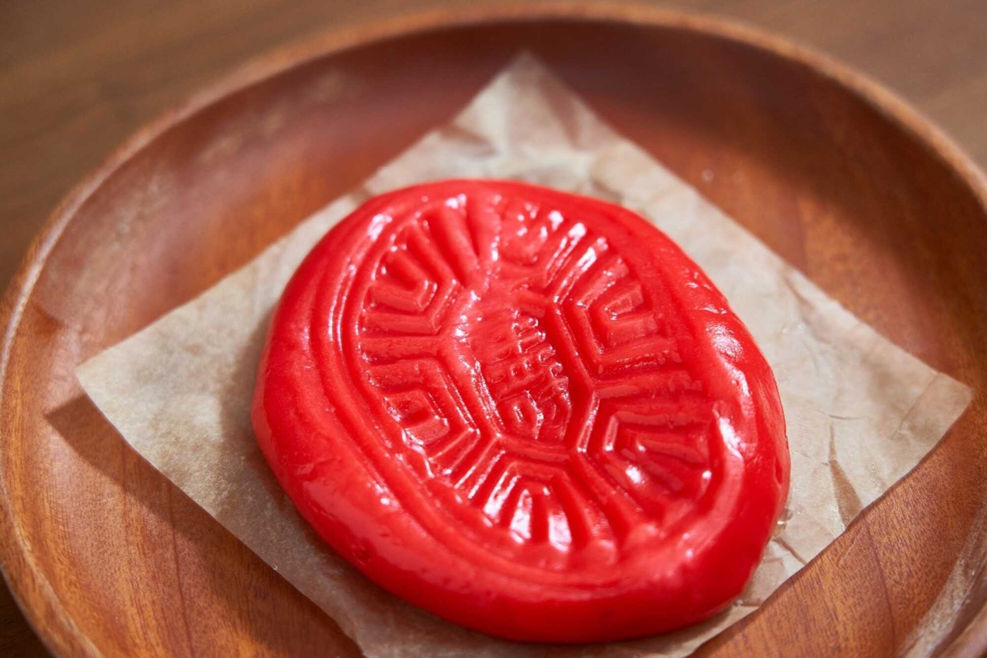 傳統紅龜粿呈鮮紅色橢圓造型,表面壓印龜紋吉祥圖案。