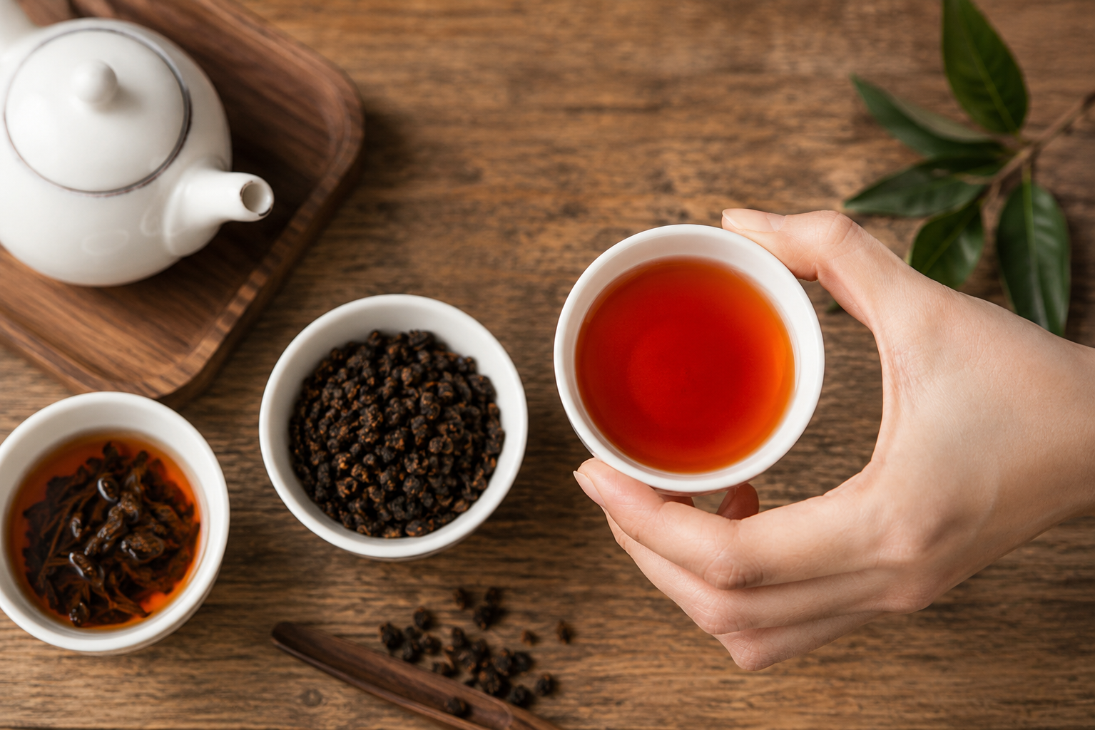 台東紅烏龍茶呈琥珀紅色茶湯,搭配茶葉與茶壺展現品茗情境